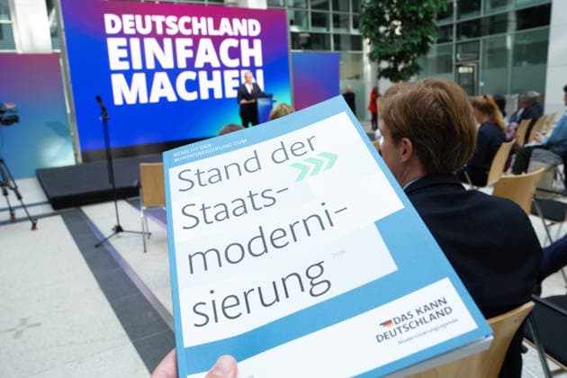 Statement des Bundesminister fuer Digtales zur Staatsmodernisierung Der Bericht in gebundener Form im Hintergrund Dr. Karsten Wildberger beim Statement zum Kabinettbeschluss des Berichts zu 1 Jahr Staatsmodernisierung, Berlin, 07.10.2026 Berlin Berlin Deutschland