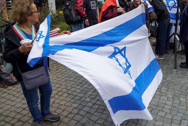 CNTV MAHNWACHE - Demonstranten auf der Strasse die Teilnehmer mit Deutschland Israel Fahnen bei der Mahnwache anlaesslich des 3.Jahrestages des Ueberfalls und Massakers in Israel Menschen versammeln sich die Menschen vor dem Audimax im Grindelvietel in Hamburg am 07.10.2026 Hamburg Deutschland
