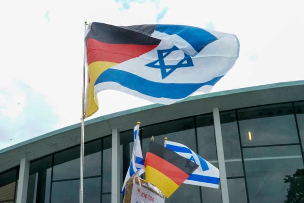 CNTV MAHNWACHE - Demonstranten auf der Strasse die Teilnehmer mit Deutschland Israel Fahnen bei der Mahnwache anlaesslich des 3.Jahrestages des Ueberfalls und Massakers in Israel Menschen versammeln sich die Menschen vor dem Audimax im Grindelvietel in Hamburg am 07.10.2026 Hamburg Deutschland