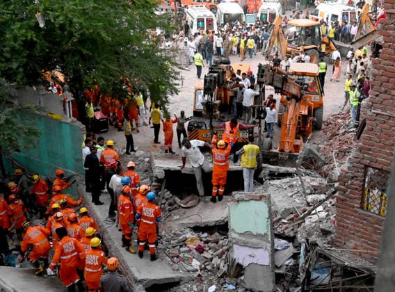 NEW DELHI, INDIA - OCTOBER 7: National Disaster Response Force (NDRF) jawans, Delhi Fire Service personnel, and local residents navigate heavy rubble during a search and rescue operation after a four-storey residential building collapsed in the New Seemapuri area of Shahdara on October 7, 2026, in New Delhi, India. The structural collapse occurred around 3:30 PM behind the local fish market, trapping multiple residents under concrete slabs and damaging two adjoining houses. At least one minor died while eight people were rescued and rushed to Rajiv Gandhi Super Speciality Hospital for emergency medical treatment as sniffer dogs and excavators worked late into the evening to locate remaining trapped survivors. (Photo by Ishant Chauhan Hindus