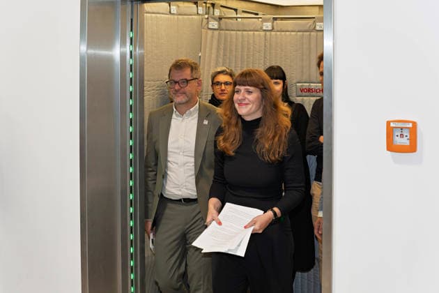 Berlin, 08.10.2026: Kerstin Wolter-Ehling (Die Linke, vorn) und Werner Graf (Bündnis 90 Die Grünen, l.) kommen nach Abschluss der Vorgespräche von Die Linke Berlin, Bündnis 90 Die Grünen Berlin und SPD Berlin aus dem Fahrstuhl zum gemeinsamen Pressestatement im Foyer des Hauses der Statistik. Pressestatement von Linke, Grünen und SPD in Berlin