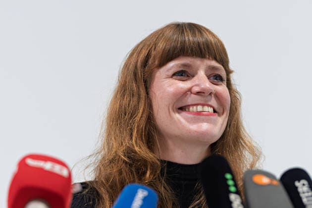 Berlin, 08.10.2026: Kerstin Wolter-Ehling (Die Linke) lacht beim gemeinsamen Pressestatement von Die Linke Berlin, Bündnis 90 Die Grünen Berlin und SPD Berlin nach Abschluss der Vorgespräche im Foyer des Hauses der Statistik hinter den Mikrofonen der Medien. Pressestatement von Linke, Grünen und SPD in Berlin