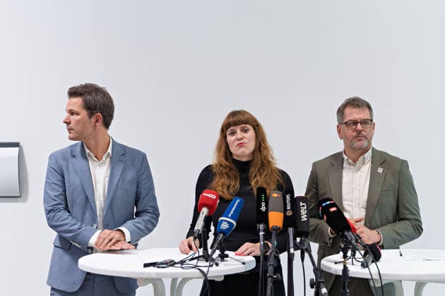 Berlin, 08.10.2026: Kerstin Wolter-Ehling (Die Linke, M.) spricht neben Steffen Krach (SPD, l.) und Werner Graf (Bündnis 90 Die Grünen, r.) beim gemeinsamen Pressestatement nach Abschluss der Vorgespräche ihrer Parteien im Foyer des Hauses der Statistik vor den Mikrofonen. Pressestatement von Linke, Grünen und SPD in Berlin