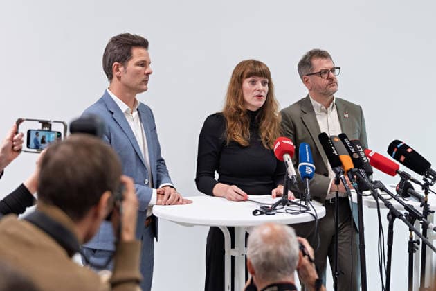 Berlin, 08.10.2026: Kerstin Wolter-Ehling (Die Linke, M.) spricht neben Steffen Krach (SPD, l.) und Werner Graf (Bündnis 90 Die Grünen, r.) beim gemeinsamen Pressestatement nach Abschluss der Vorgespräche ihrer Parteien im Foyer des Hauses der Statistik, im Vordergrund fotografieren Journalisten. Pressestatement von Linke, Grünen und SPD in Berlin