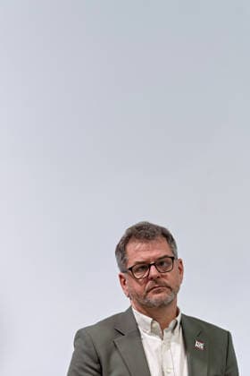 Berlin, 08.10.2026: Werner Graf (Bündnis 90 Die Grünen) hört beim gemeinsamen Pressestatement von Die Linke Berlin, Bündnis 90 Die Grünen Berlin und SPD Berlin nach Abschluss der Vorgespräche im Foyer des Hauses der Statistik mit zur Seite geneigtem Kopf zu. Pressestatement von Linke, Grünen und SPD in Berlin