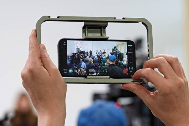 Berlin, 08.10.2026: Hände halten ein Smartphone, mit dem das gemeinsame Pressestatement von Die Linke Berlin, Bündnis 90 Die Grünen Berlin und SPD Berlin nach Abschluss der Vorgespräche im Foyer des Hauses der Statistik gefilmt wird. Pressestatement von Linke, Grünen und SPD in Berlin