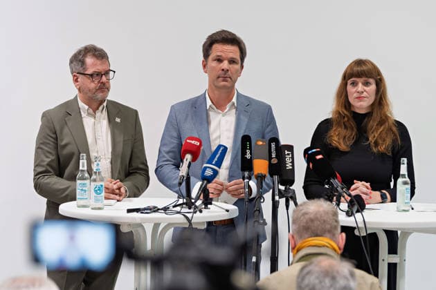 Berlin, 08.10.2026: Werner Graf (Bündnis 90 Die Grünen, l.), Steffen Krach (SPD, M.) und Kerstin Wolter-Ehling (Die Linke, r.) stehen beim gemeinsamen Pressestatement nach Abschluss der Vorgespräche ihrer Parteien im Foyer des Hauses der Statistik vor den Mikrofonen der Medien. Pressestatement von Linke, Grünen und SPD in Berlin