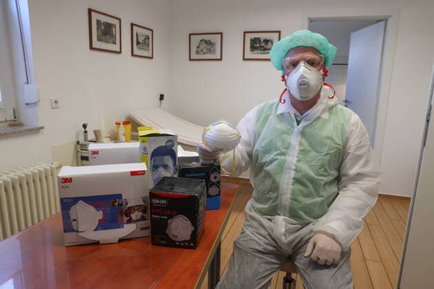 Coronavirus, Arbeit mit FFP2-Maske und Schutzkleidung in einer Arztpraxis