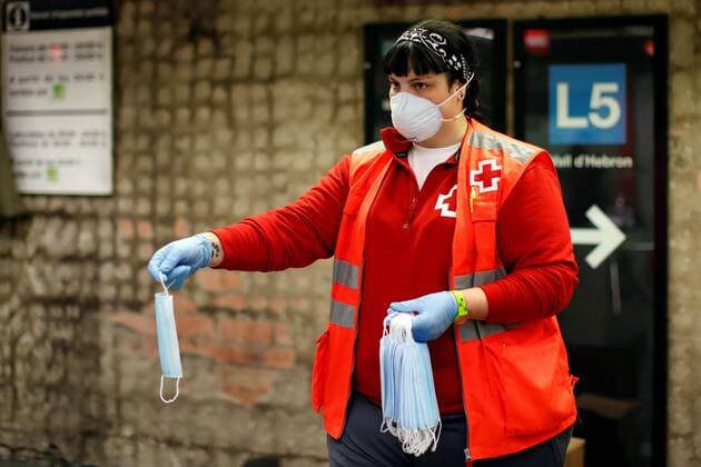 Coronavirus in Spanien, Rotes Kreuz verteilt Schutzmasken an Pendler auf dem Weg zur Arbeit