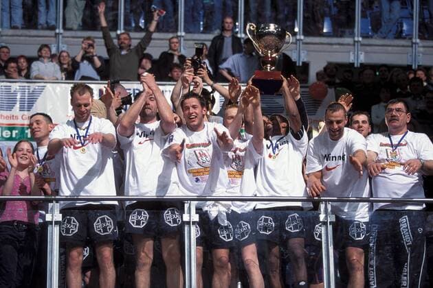 Mannschaftsjubel SCM mit dem Champions-League-Pokal, v.li.: Olafur Stefansson, Steffen Stiebler, Bennet Wiegert, Christian Schöne, Joel Abati, Uwe Mäuer und Co-Trainer Githa Licu Handball EC 1 Herren Champions League 2001 2002, Finale, Endspiel, SC Magdeburg, Vdia Totale Bördelandhalle Magdeburg Freude,