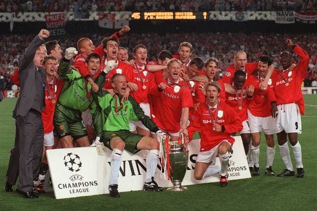 IMAGO Iconic Moments, Fußball Mannschaftsbild ManU mit Pokal vorn: Beckham (re.), Torwart Schmeichel; hinten v.re.: Cole, Giggs, Stam, Yorke, P. Neville, Sheringham, Johnson, May, Solskjaer, Butt, G. Neville, Brown, Torhüter van der Gouw, Irwin, Blomqvist und Scholes Fußball EC 1 Herren Champions League 1998 1999, Manchester United - FC Bayern München 2:1, Finale, Endspiel, Vneg Totale Pokal, Trophäe Barcelona Freude, Begeisterung,