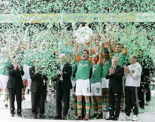 Fußball, SV Werder Bremen, Deutscher Meister 2004 Frank Baumann (Bremen, Mitte) präsentiert im grün-weißen Konfettiregen die Meisterschale unter dem Applaus von DFB-Generalsekretär Horst R. Schmidt (Deutschland, 2.v.re.) und Trainer Thomas Schaaf (Bremen, re.) Fußball 1. BL Herren Saison 2003 2004, SV Werder Bremen, Funktionär, Funktionäre, Präsidium, Vorstand, Verband Totale Präsidium, Vorstand, Coach Bremen Freude, Begeisterung,