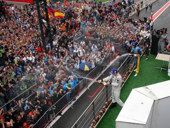 Siegerehrung Großer Preis von Belgien 2005 - Sieger Kimi Räikkönen (Finnland McLaren Mercedes, li.) Fernando Alonso (Spanien Renault, Mitte) und Jenson Button (Großbritannien BAR Honda) feiern mit einer Sektdusche für die Zuschauer Motorsport Grand Prix Herren Großer Preis von Belgien 2005, Formel 1 Weltmeisterschaft, F1, F, GP, WM, Totale Saisonhighlight Spa-Francorchamps Masse, Freude, Begeisterung,