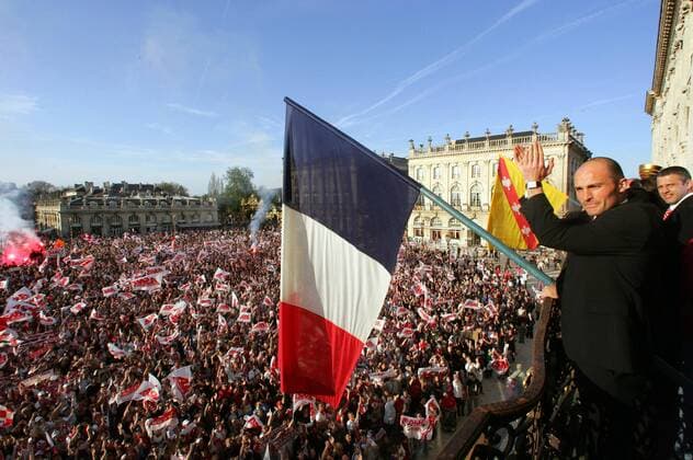 Cedric Lecluse (Nancy) genießt auf dem Balkon des Rathauses den überwältigenden Empfang zahlreicher Fans, die sich auf dem Place Stanislas versammelt haben - (pan13782) Fußball Herren Coupe de la Ligue 2005 2006, Französischer Ligapokal, Ligue 1, 1. Französische Liga, Empfang Totale Landesfahne, Nationalfahne, Nationalfahnen Nancy, Fanfahne, Fanfahnen Masse,