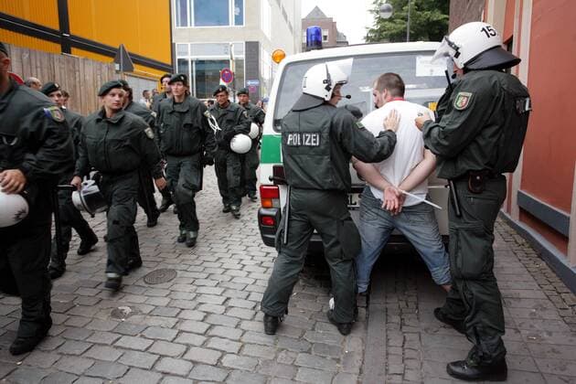 Während weitere Polizisten zum Einsatz ausrücken, wird ein deutscher Hooligan verhaftet Fußball WM Herren Nationalteam 2006, Security, Sicherheit, Sicherheitsdienst, Sicherheitskräfte, Polizist, Polizei Gruppe Ausschreitungen, Randale, Krawall, Krawalle Köln Polizeieinsatz Fußball WM Herren Nationalteam 2006, Security, Sicherheit, Sicherheitsdienst, Sicherheitskräfte, Polizist, Polizei Gruppe Ausschreitungen, Randale, Krawall, Krawalle Köln Polizeieinsatz