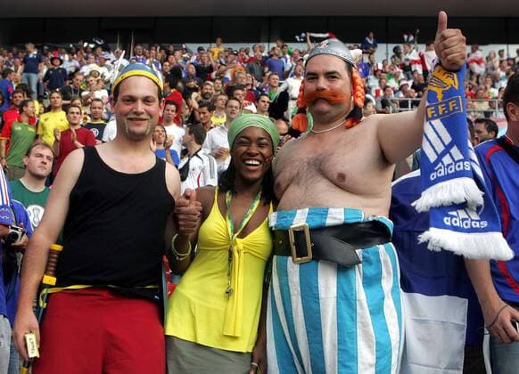 Asterix und Obelix haben einen weiblichen togolesischen Fan in ihre Mitte genommen Fußball Herren WM 2006, Länderspiel, Nationalteam, Gruppe G, Togo - Frankreich 0:2, Fanfreundschaft, Fangruppe Vdig Gruppe Comicfigur, Comicfiguren Köln, Kopfbedeckung, Helm, Völkerverständigung Harmonie Fußball Herren WM 2006, Länderspiel, Nationalteam, Gruppe G, Togo - Frankreich 0:2, Fanfreundschaft, Fangruppe Vdig Gruppe Comicfigur, Comicfiguren Köln, Kopfbedeckung, Helm, Völkerverständigung Harmonie