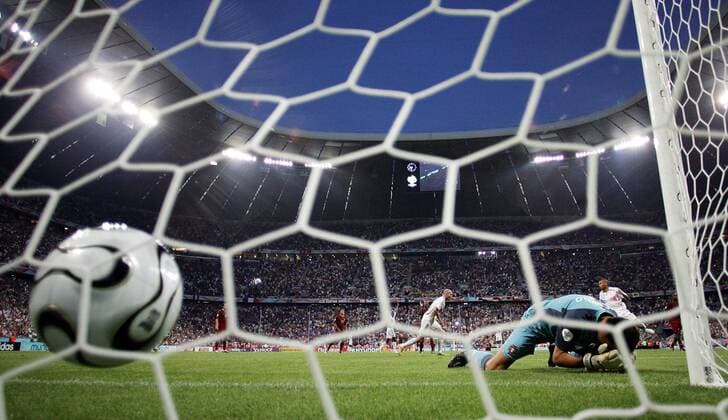 Ball im Netz: Torwart Ricardo (Portugal) liegt geschlagen am Boden, dahinter bejubelt Zinedine Zidane (Frankreich, hi.) sein Elfmetertor im ausverkauften FIFA World Cup Stadium in München - Fußball WM Herren WM 2006, Länderspiel, Nationalteam, Halbfinale, Nationaltrikot Totale Worldcup Stadion München Fußball WM Herren WM 2006, Länderspiel, Nationalteam, Halbfinale, Nationaltrikot Totale Worldcup Stadion München