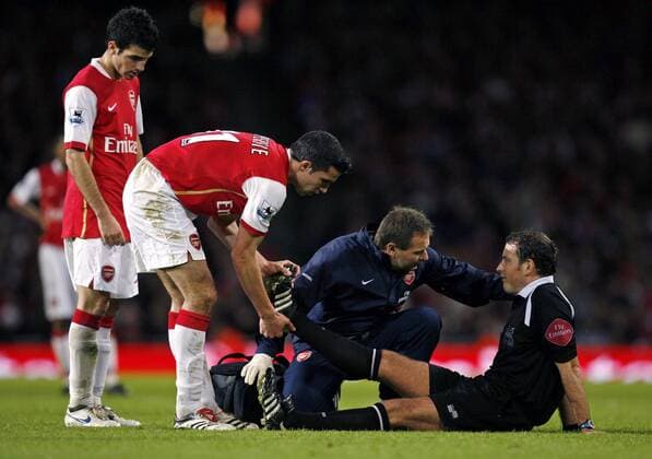 Schiedsrichter Mark Clattenburg hat Wadenkrämpfe, Physiotherapeut Gary Lewin (2.v.re.) erkundigt sich nach dem Befinden und Robin van Persie (2.v.li., beide Arsenal) hilft beim Stretching - EDITORIAL USE ONLY. No use with unauthorised audio, video, data, fixture lists, club league logos or live services. Online in-match use limited to 120 images, no video emulation. No use in betting, games or single club league player publications. Fußball Herren English Premier League 2006 2007, 1. Englische Liga, Arsenal FC London Gruppe London Fußball Herren English Premier League 2006 2007, 1. Englische Liga, Arsenal FC London Gruppe London