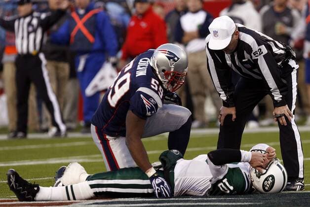 Rosevelt Colvin (New England Patriots, li.) und Schiedsrichter Bill Vinovich kümmern sich um den verletzt am Boden liegenden Chad Pennington (New York Jets) - (BOS2007010716) American Football Herren NFL Postseason 2006 2007, Playoffs, Playoff, Play Offs, Off, Wildcardgame, Wildcard Game, Wild Card Gruppe Foxboro American Football Herren NFL Postseason 2006 2007, Playoffs, Playoff, Play Offs, Off, Wildcardgame, Wildcard Game, Wild Card Gruppe Foxboro