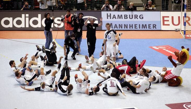 Bundestrainer Heiner Brand (Deutschland, Mitte stehend) bringt seine Mannschaft mit einem simulierten Bowlingwurf vor Freude zu Fall Handball WM Herren WM 2007, Länderspiel, Nationalteam, Nationaltrikot, Hauptrunde Gruppe I Totale Glücksbringer, Hanniball, Hamburg Mannheimer Dortmund, adidas, Freude, Begeisterung, Handball WM Herren WM 2007, Länderspiel, Nationalteam, Nationaltrikot, Hauptrunde Gruppe I Totale Glücksbringer, Hanniball, Hamburg Mannheimer Dortmund, adidas, Freude, Begeisterung,