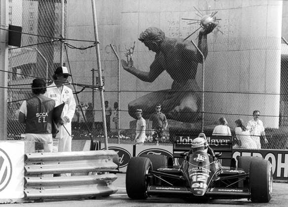 Ayrton Senna (Brasilien Lotus Renault) in seinem Boliden vor der The Spirit of Detroit Statue - Motorsport Grand Prix Herren Großer Preis der USA 1986, Formel 1 Weltmeisterschaft, F1, F, GP, WM Totale Detroit Motorsport Grand Prix Herren Großer Preis der USA 1986, Formel 1 Weltmeisterschaft, F1, F, GP, WM Totale Detroit