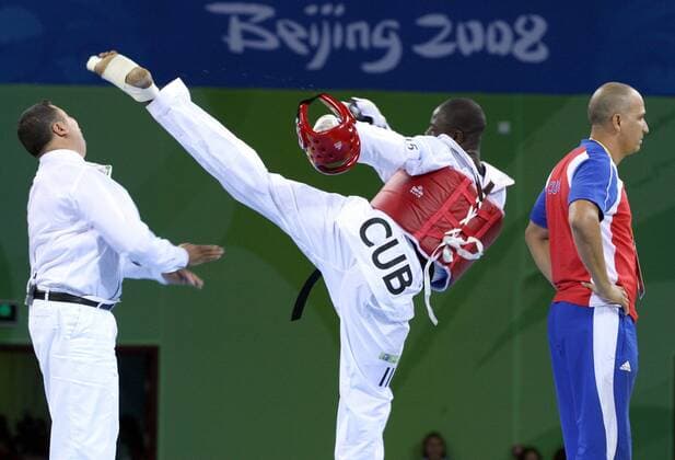 Olympia, Historie, Rückblick auf die Sommerspiele 2008 in Peking Angel Valodia Matos (Kuba) tritt Hauptkampfrichter Chakir Chelbat (Schweden, li.) mit voller Wucht - der Eklat mündete in einer lebenslangen Sperre für Matos - Taekwondo OS Sommer Herren Olympische Spiele 2008, Sommerspiele, Tae Kwon Do, Taek Won, Taekwon, Klasse über 80kg o0 Aufmacher Gruppe o0 Kampfrichter, Schiri, Mattenrichter, Skandal, Peking o0 Sperre gesperrt lebenslang lebenslange, Dynamik, Kampf Spannung,