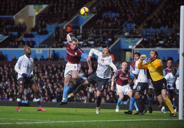 Richard Dunne (2.L) of Aston Villa forces a save from Arsenal goalkeeper Manuel Almunia , Barclays Premier League, Aston Villa - Arsenal FC London, 27th January, 2010 - EDITORIAL USE ONLY. No use with unauthorised audio, video, data, fixture lists, club league logos or live services. Online in-match use limited to 120 images, no video emulation. No use in betting, games or single club league player publications.