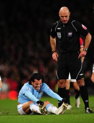 Carlos Tevez (L) of Manchester City grimaces after coming off wores in a tackle - Carling Cup, Semi Final 2nd Leg, Manchester United - Manchester City, 27th January, 2010 - EDITORIAL USE ONLY. No use with unauthorised audio, video, data, fixture lists, club league logos or live services. Online in-match use limited to 120 images, no video emulation. No use in betting, games or single club league player publications.
