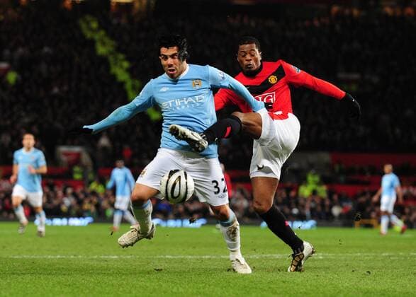 Carlos Tevez (L) of Manchester City challenged by Patrice Evra of Manchester United - Carling Cup, Semi Final 2nd Leg, Manchester United - Manchester City, 27th January, 2010 - EDITORIAL USE ONLY. No use with unauthorised audio, video, data, fixture lists, club league logos or live services. Online in-match use limited to 120 images, no video emulation. No use in betting, games or single club league player publications.