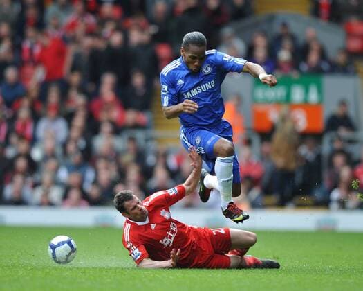 Jamie Carragher (L) of Liverpool slides in on Didier Drogba of Chelsea , Barclays Premier League, FC Liverpool v Chelsea FC London, 2nd May, 2010 EDITORIAL USE ONLY. No use with unauthorised audio, video, data, fixture lists, club league logos or live services. Online in-match use limited to 120 images, no video emulation. No use in betting, games or single club league player publications.
