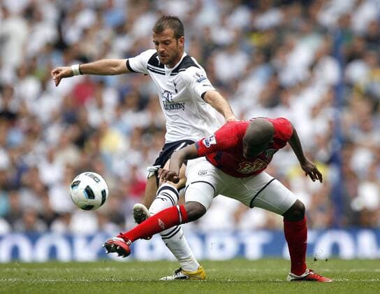 Youssuf Mulumbu of West Bromwich Albion holds off Rafael van der Vaart of Tottenham Hotspur during the English Premier League football match between Tottenham Hotspur and West Bromwich Albion at White Hart Lane, London, England, on April 23, 2011. Barclays Premier League Tottenham Hotspur (white) v West Bromwich Albion (red) 23rd April, 2011 EDITORIAL USE ONLY. No use with unauthorised audio, video, data, fixture lists, club league logos or live services. Online in-match use limited to 120 images, no video emulation. No use in betting, games or single club league player publications.