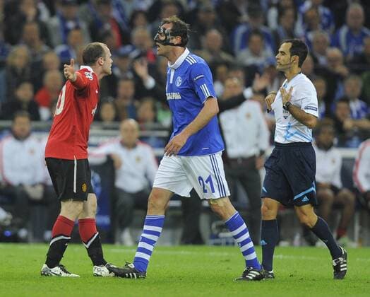 Wayne Rooney of Manchester United complains to the referee following his foul by Christoph Metzelder (C) of FC Schalke 04 - FC Schalke 04 (blue) - Manchester United (ManU) - EDITORIAL USE ONLY. No use with unauthorised audio, video, data, fixture lists, club league logos or live services. Online in-match use limited to 120 images, no video emulation. No use in betting, games or single club league player publications.