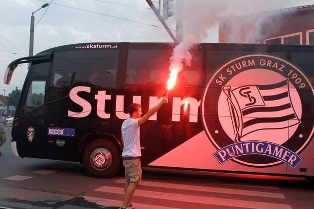 FUSSBALL - UEFA CL Quali, GRAZ,AUSTRIA,03.AUG.11 - FUSSBALL - UEFA Champions League, Qualifikation, SK Sturm Graz. Bild zeigt den Mannschaftsbus von Sturm und einen Fan. Keywords: Bengalisches Feuer, Rauch.