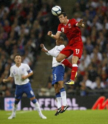 Gareth Bale of Wales and Ashley Cole of England leap for the ball during the Euro 2012 qualifying match between England and Wales at Wembley Stadium, London, England, on September 6, 2011. Photo Credit SPORTIMAGE JAKE BADGER European Championship Qualifying Group G England v Wales 6th September, 2011 EDITORIAL USE ONLY. No use with unauthorised audio, video, data, fixture lists, club league logos or live services. Online in-match use limited to 120 images, no video emulation. No use in betting, games or single club league player publications.