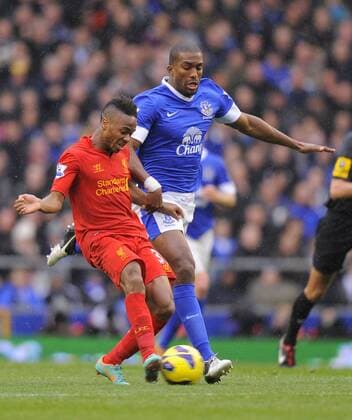Raheem Sterling of Liverpool tussles with Sylvain Distin of Everton - Barclays Premier League - Everton vs Liverpool - Goodison Park Stadium - Liverpool - 28 10 12 - Picture Simon Bellis Sportimage EDITORIAL USE ONLY. No use with unauthorised audio, video, data, fixture lists, club league logos or live services. Online in-match use limited to 120 images, no video emulation. No use in betting, games or single club league player publications.