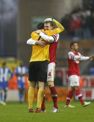 Arsenal s Per Mertesacker celebrates with Wojciech Szscesny at the final whistle..Wigan Athletic v Arsenal FC London - Barclays Premier League - JJB Stadium, Wigan- 22 12 12 - EDITORIAL USE ONLY. No use with unauthorised audio, video, data, fixture lists, club league logos or live services. Online in-match use limited to 120 images, no video emulation. No use in betting, games or single club league player publications.
