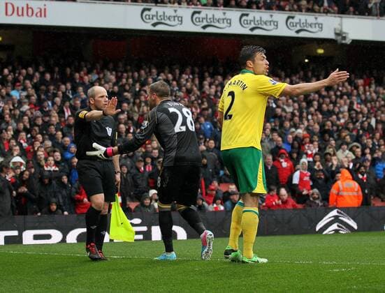 Norwich s Mark Bunn protests after the award of a penalty with assistant referee Richard West.. FC Arsenal London vs Norwich City - Barclays Premier League - Emirates Stadium, London- 12 04 13 - EDITORIAL USE ONLY. No use with unauthorised audio, video, data, fixture lists, club league logos or live services. Online in-match use limited to 120 images, no video emulation. No use in betting, games or single club league player publications.