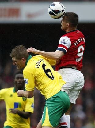 LONDON, April 13, 2013 - Lukas Podolski (R) of Arsenal vies with Michael Turner of Norwich during their Barclays Premier League match at the Emirates Stadium in London, Britain, on April 13, 2013. Arsenal won 3-1. (Xinhua Wang Lili)