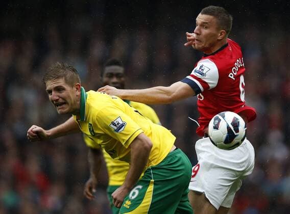 LONDON, April 13, 2013 - Lukas Podolski (R) of Arsenal vies with Michael Turner of Norwich during their Barclays Premier League match at the Emirates Stadium in London, Britain, on April 13, 2013. Arsenal won 3-1. (Xinhua Wang Lili)