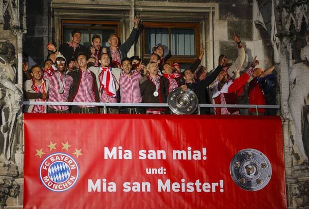Philipp Lahm (Bayern 21) Jubel, Freude, Emotionen, Feiern, Lachen, jubelt, freuen, reisst die Arme hoch, ballt die Faust mit Meisterschale, FCB 11, Bastian Schweinsteiger (Bayern 31), Anatoliy Tymoshchuk FCB Nr. 44 feiern auf dem Rathausbalkon am Muenchner Marienplatz mit dem Transparent Mia san mia und Mia san Meister FC Bayern München - - Der FC Bayern ist deutscher Fussballmeister 2013