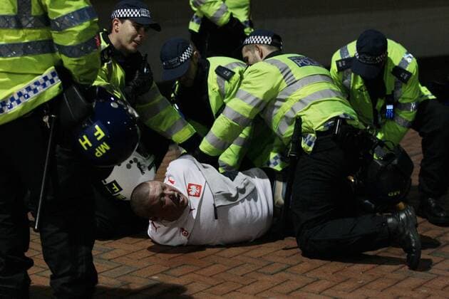 Poland - World Cup Qualifier . . Wembley, London . . 15.10.2013 A Polish fan is restrained by police outside Wembley Stadium. EDITORIAL USE ONLY. No use with unauthorised audio, video, data, fixture lists, club league logos or live services. Online in-match use limited to 120 images, no video emulation. No use in betting, games or single club league player publications.