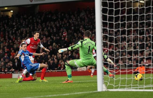 Arsenal s Mesut Özil scoring his sides second goal - Arsenal FC v Hull City Tigers - Premier League - Emirates Stadium - London - 04 12 2013 - Pic DavidxKlein Sportimage EDITORIAL USE ONLY. No use with unauthorised audio, video, data, fixture lists, club league logos or live services. Online in-match use limited to 120 images, no video emulation. No use in betting, games or single club league player publications.