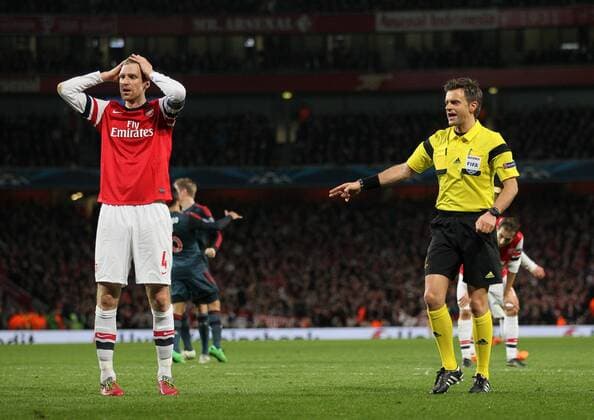 Arsenal s Per Mertesacker looks on dejected as referee Nicola Rizzoli points to the spot - FC Arsenal London vs FC Bayern Munich - UEFA Champions League - Emirates Stadium - London - England - 19 02 2014 - EDITORIAL USE ONLY. No use with unauthorised audio, video, data, fixture lists, club league logos or live services. Online in-match use limited to 120 images, no video emulation. No use in betting, games or single club league player publications.