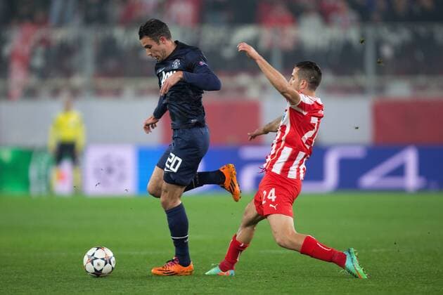 Robin van Persie of Manchester United skips past Kostas Manolas of Olympiacos - UEFA Champions League First Knockout Round - Olympiacos Piräus vs. Manchester United (ManU) - Karaiskakh Stadium - Athens - 25th February 2014 - EDITORIAL USE ONLY. No use with unauthorised audio, video, data, fixture lists, club league logos or live services. Online in-match use limited to 120 images, no video emulation. No use in betting, games or single club league player publications.