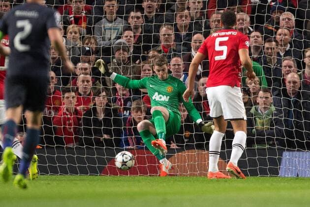 David de Gea of Manchester United makes a save with his feet - UEFA Champions League Round of 16 - Manchester United vs. Olympiacos - Old Trafford - Manchester - England - 19th March 2014 - Picture Philip Oldham Sportimage EDITORIAL USE ONLY. No use with unauthorised audio, video, data, fixture lists, club league logos or live services. Online in-match use limited to 120 images, no video emulation. No use in betting, games or single club league player publications.