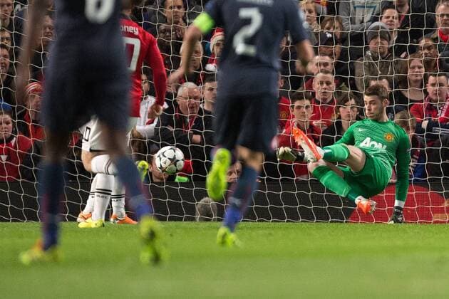 David de Gea of Manchester United makes a save with his feet - UEFA Champions League Round of 16 - Manchester United vs. Olympiacos - Old Trafford - Manchester - England - 19th March 2014 - Picture Philip Oldham Sportimage EDITORIAL USE ONLY. No use with unauthorised audio, video, data, fixture lists, club league logos or live services. Online in-match use limited to 120 images, no video emulation. No use in betting, games or single club league player publications.
