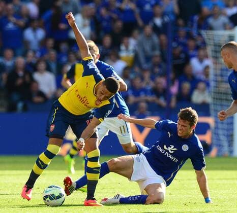 Alex Oxlade-Chamberlain of Arsenal tackled by Dean Hammond of Leicester City - Barclays Premier League - Leicester City vs Arsenal FC London - England - 30th August 2014 - EDITORIAL USE ONLY. No use with unauthorised audio, video, data, fixture lists, club league logos or live services. Online in-match use limited to 120 images, no video emulation. No use in betting, games or single club league player publications.