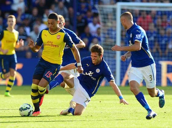 Alex Oxlade-Chamberlain of Arsenal tackled by Dean Hammond of Leicester City - Barclays Premier League - Leicester City vs Arsenal FC London - England - 30th August 2014 - EDITORIAL USE ONLY. No use with unauthorised audio, video, data, fixture lists, club league logos or live services. Online in-match use limited to 120 images, no video emulation. No use in betting, games or single club league player publications.