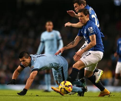 Sergio Kun Aguero of Manchester City tussles with Seamus Coleman and Muhamed Besic of Everton which leads to him going off injured - Barclays Premier League - Manchester City vs Everton FC - Etihad Stadium - Manchester - England - 6th December 2014 - EDITORIAL USE ONLY. No use with unauthorised audio, video, data, fixture lists, club league logos or live services. Online in-match use limited to 120 images, no video emulation. No use in betting, games or single club league player publications.