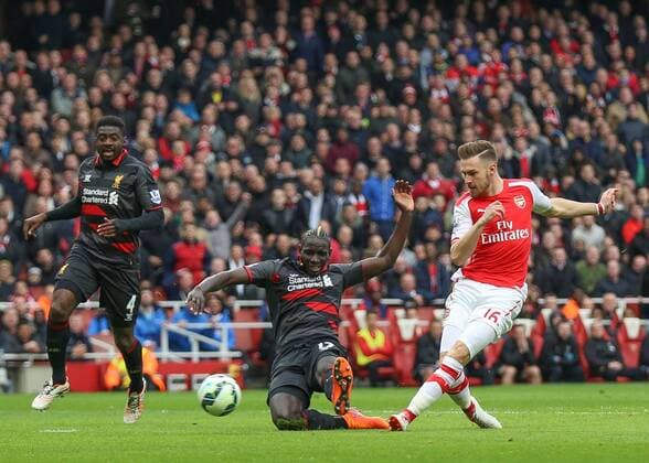 Football - 2014 2015 - Barclays Premier League, - Arsenal Vs Liverpool, Arsenal s Aaron Ramsey slides the ball past Liverpool s Mamadou Sakho at The Emirates Stadium COLORSPORT DANIEL BEARHAM ARS_LIV